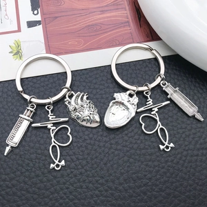 Detailed view of silver medical keychain with heart, stethoscope, and syringe charms