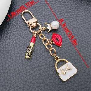 Detailed view of fashion keychain with crown pearl bag, lipstick and lip charms