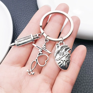 Antique silver medical keychain with syringe, stethoscope heart, and anatomical heart charms