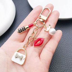 Detailed view of alloy keychain with red lipstick, handbag, lips and pearl charms