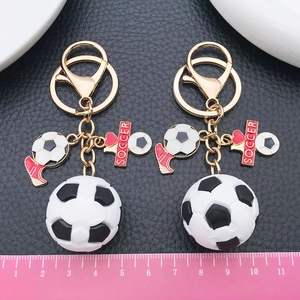 3D soccer ball keychain with football boot charm and soccer metal tag on black background