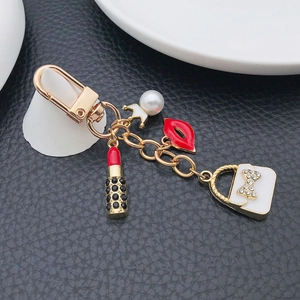 Fashionable golden keychain with enamel handbag, lipstick, and crown pearl charms