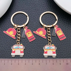 Firefighting theme keychain set with red truck, helmet and extinguisher on black leather