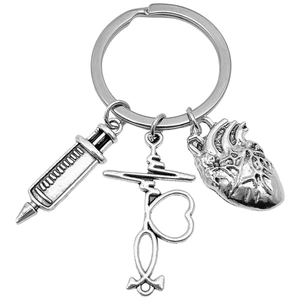 Antique silver medical keychain with syringe, heart and EKG line charms on white background