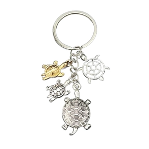Sea turtle keychain set with vintage silver and gold metal charms on white background