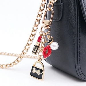 Détail du porte-clés avec rouge à lèvres, sac à main et couronne sur un sac en cuir noir