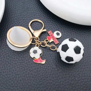 Detail of 3D soccer keychain with red cleat tag and golden alloy clasp on black leather