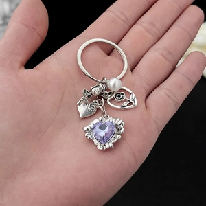 Détail du porte-clés avec cristal violet, perle et pendentifs de roses argentées