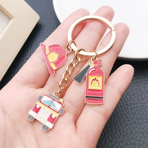 Detail of firefighter themed keychain featuring red helmet, truck and extinguisher charms