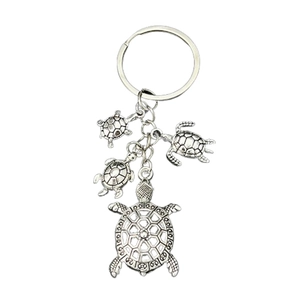 Antique silver alloy turtle keychain with multiple sea turtle pendants on white background