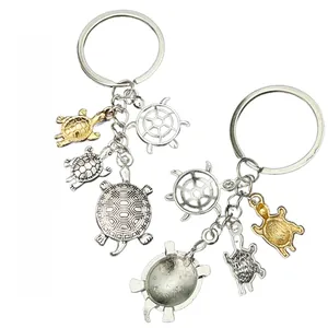 Front and back detail of multi-turtle metal keychain in antique silver and gold finish