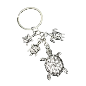 Detailed view of antique silver turtle charms on a metal keychain with geometric shell patterns