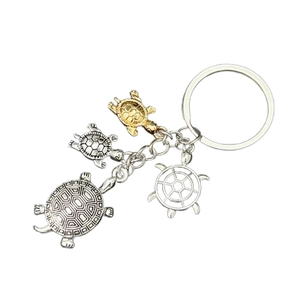 Detailed view of turtle keychain charms in antique silver and gold metal finishes