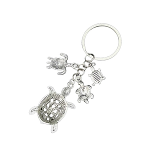 Detailed macro view of vintage silver sea turtle alloy charms on a metal keychain