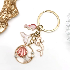 Detail of marine keychain with seahorse, mermaid and shell charms with pink enamel and pearls