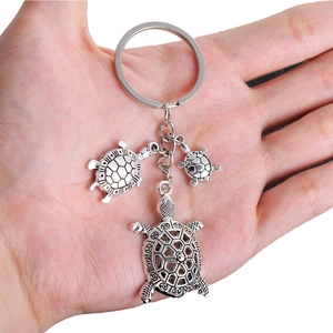 Detailed close-up of antique silver turtle keychain with three textured alloy pendants