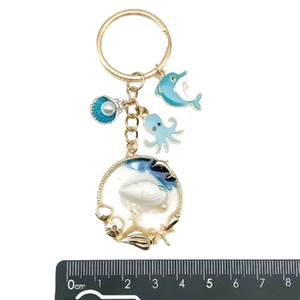 Dettaglio portachiavi a tema oceano in smalto blu con scala graduata di 8 cm inclusa