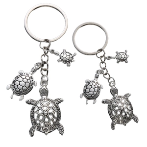 Detail showing retro silver-plated turtle keychains with intricate geometric shell patterns