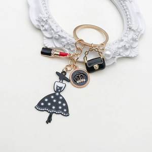 Detailed view of fashion keychain with lipstick, pearl, and black dress charms