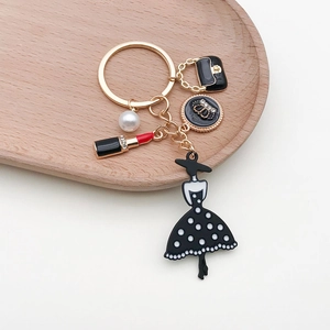 Detailed close-up of fashion keychain with gold metal handbag and pearl charms