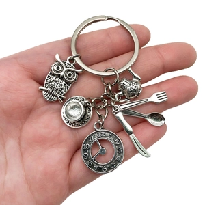 Detail of vintage silver Alice in Wonderland keychain with owl and clock charms
