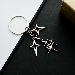Minimalist silver star keychain with hollow star charms on black and white background