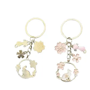Portachiavi gatto e fiori di ciliegio rosa con perle e ciondoli in smalto dorato