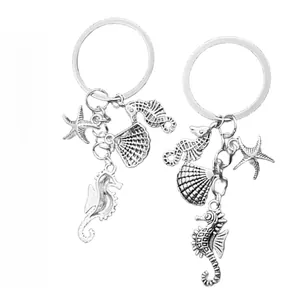 Detailed close-up of seahorse and starfish charms on vintage silver metal keychains