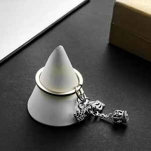 Détail de pendentifs couronne argentés et d'une cloche sur un porte-clés en métal