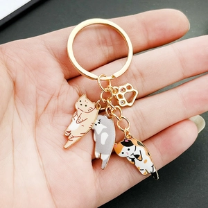 Cute golden keychain with three cartoon enamel cat charms and a small paw pendant