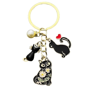 Porte-clés chat doré avec des pendentifs en émail noir et une perle blanche pour sacs à main
