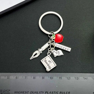 Teacher appreciation keychain with red apple, blackboard, ruler, book and pen charms