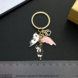 Cute cartoon cat keychain set with pink, black, and calico charms with a ruler for scale