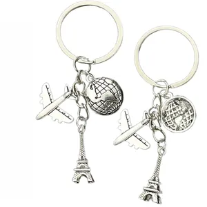 Detail showing airplane, Eiffel Tower, and globe charms on silver-plated keychains