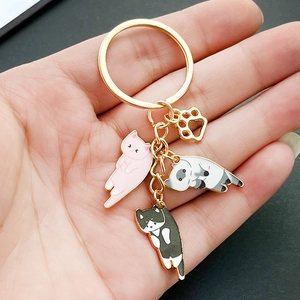 Handheld photo of cute enamel cat keychains with paw charm and colorful cartoon kittens