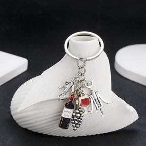 Macro view of wine bottle, glass, and corkscrew charms on a metallic keychain