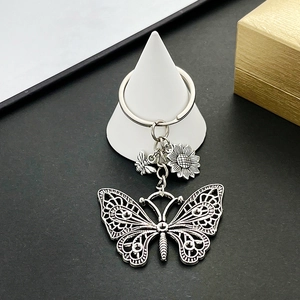 Detailed macro view of vintage silver alloy keychain with butterfly and sunflower pendants