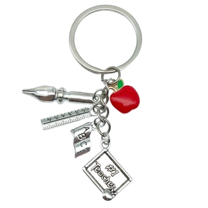 Teacher gift keychain with red apple book and silver ruler pendants on white background