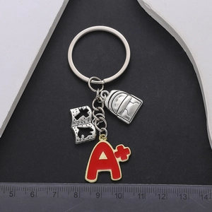 Porte-clés cartable en métal avec charme de grade A+ et pendentif livre sur fond noir