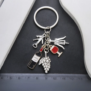 Detailed view of metal wine keychain set with wine bottle and red glass charms
