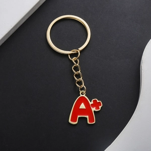 Detail of a red enamel A+ charm keychain with gold-tone finish for graduation gift