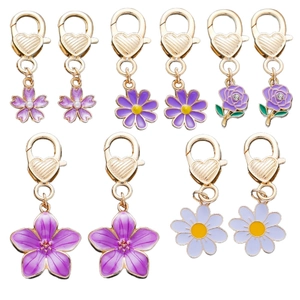 Detailed close-up of purple enamel flower charms with gold heart-shaped lobster clasps