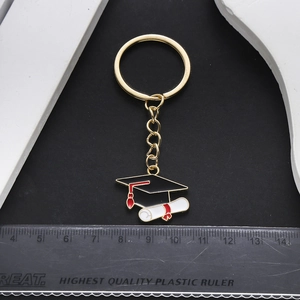 Golden graduation cap and diploma keychain with enamel details and reference ruler