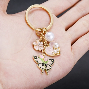 Eleganter Schlüsselanhänger mit rosa Tulpe Schmetterling Herzperle und goldfarbenem Ring