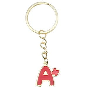 Detail of a golden A+ letter keychain with red enamel drip oil craft finish