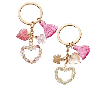 Pink heart keychain with floral tassel and pearl details shown in front and back view