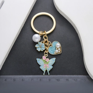 Blue heart pearl butterfly keychain with gold tulip pendant and floral accents