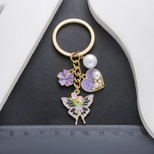 Golden keychain with purple enamel flowers, heart, faux pearls and tulip butterfly pendant