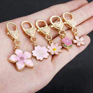 Set di cinque ciondoli floreali in smalto rosa con lega dorata e piccoli cristalli
