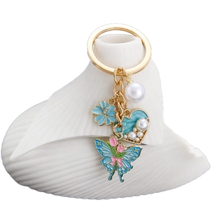Blue heart and pearl keychain with rose flower and butterfly charms in gold finish